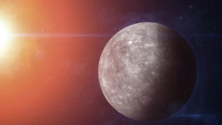 The planet Mercury in the foreground, with the sun shining on it in the top left corner.