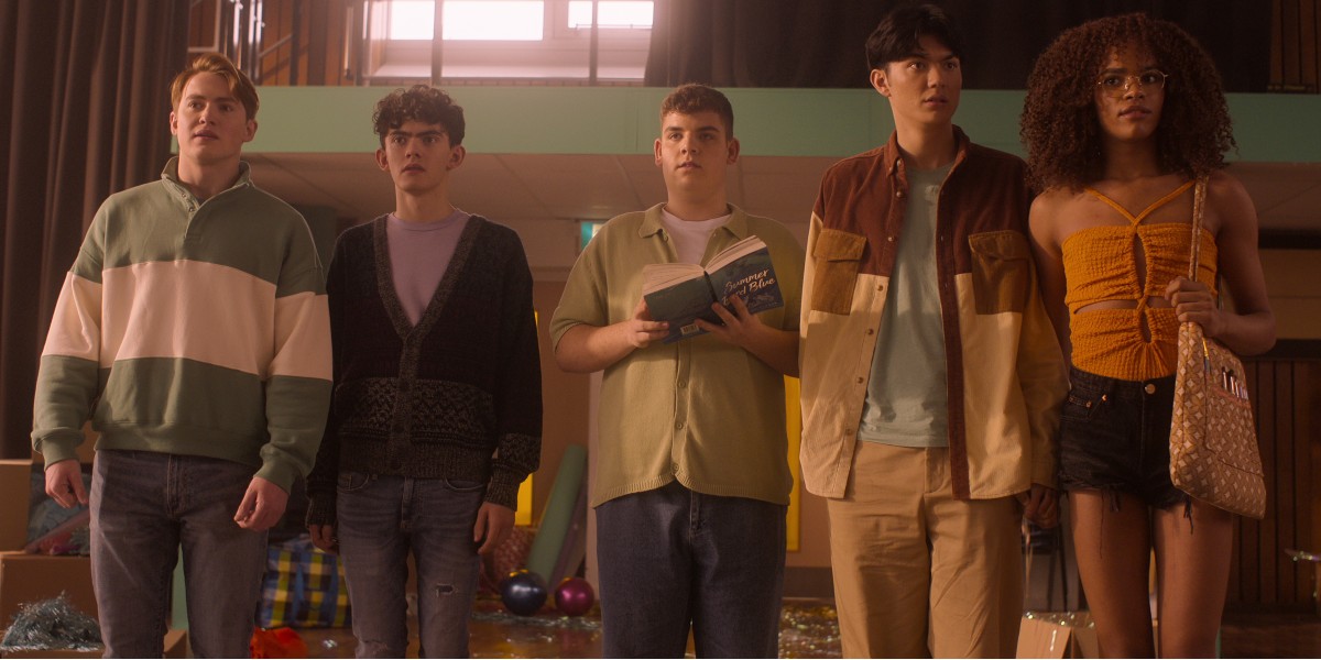 Heartstopper friends hanging out and of course Isaac has a book.