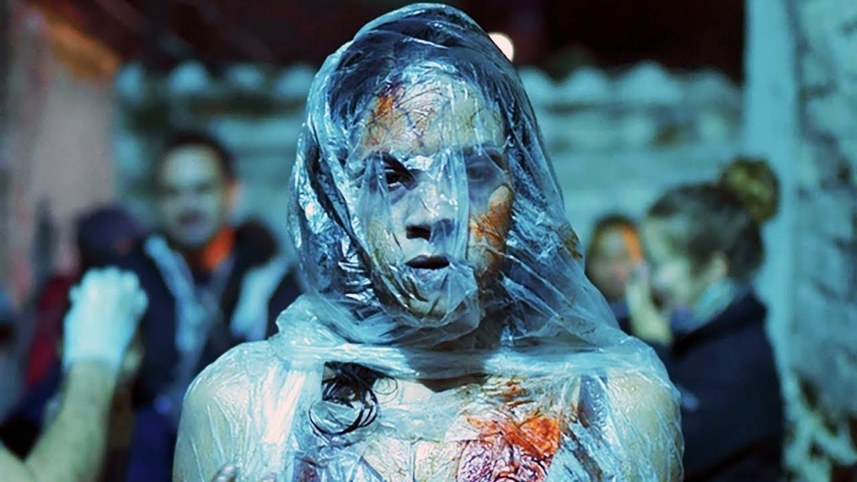 A bloodied girl wrapped in plastic stands in a crowd at night in "Tigers Are Not Afraid"