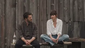Dakota Johnson sitting on a thing with Chris Evans